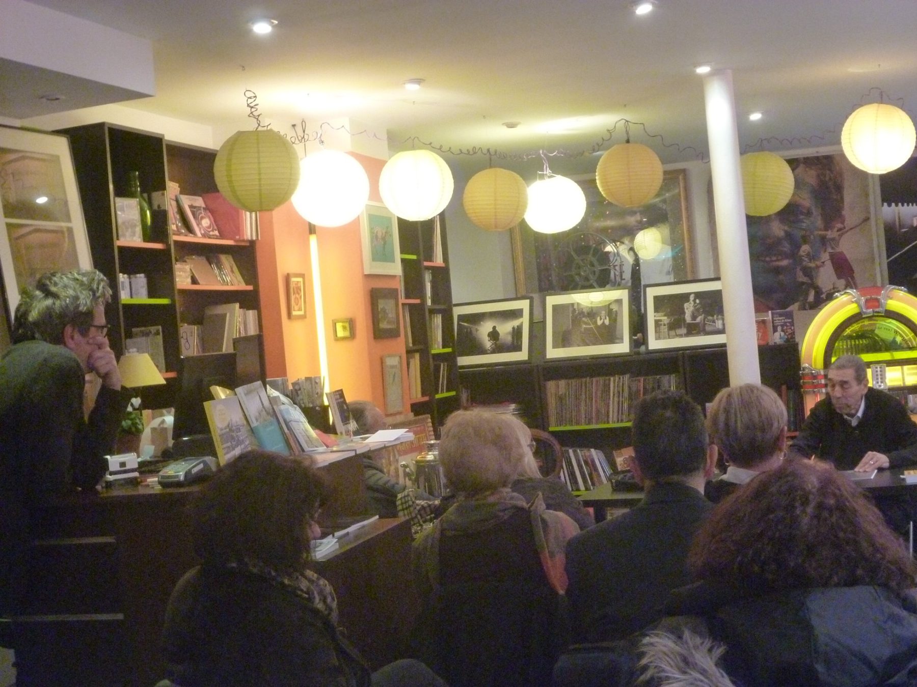 Les lecteurs assis dans la librairie écoutent l’auteur